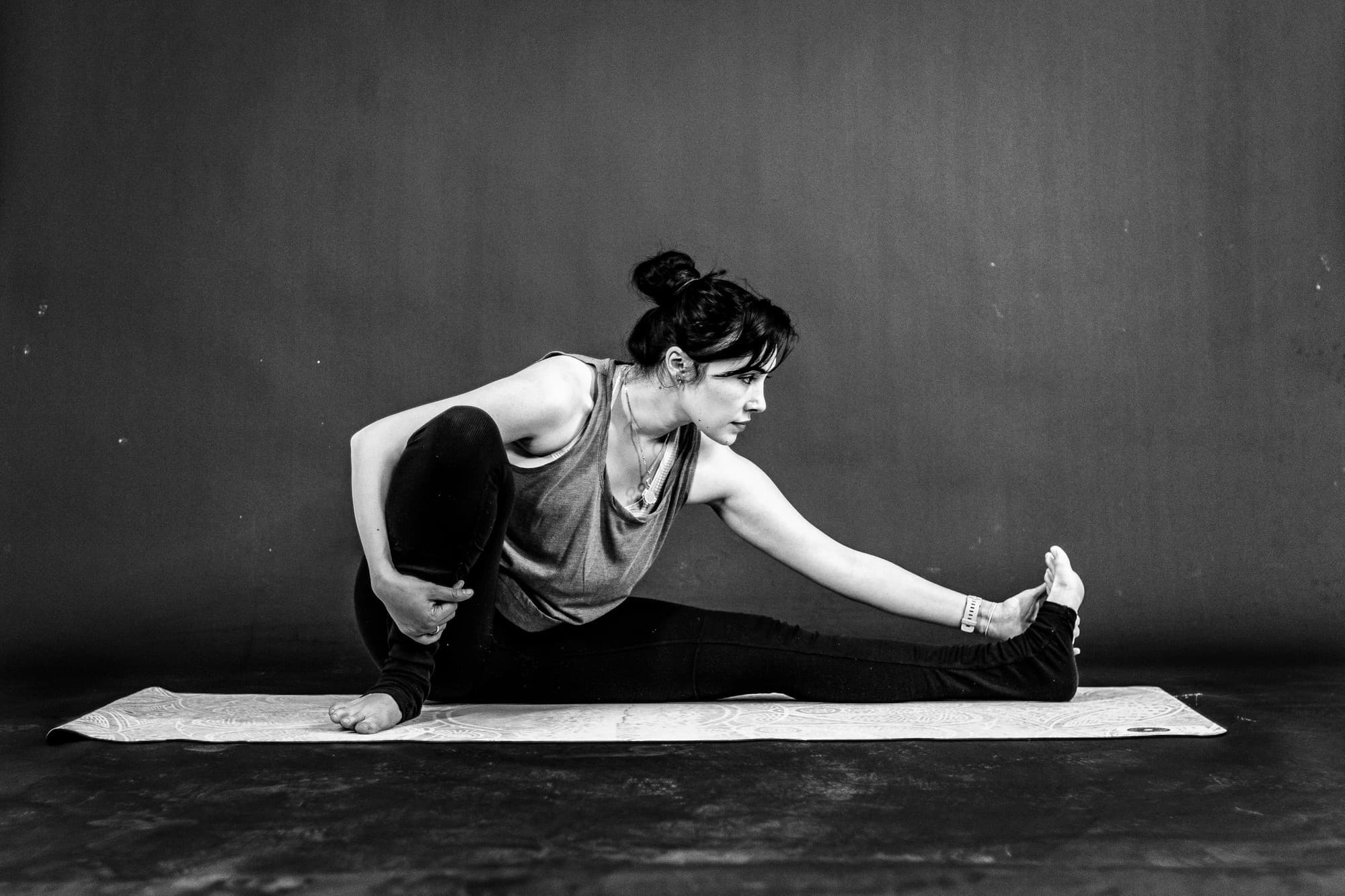 Danseuse en étirement au sol sur un tapis, exercice de barre au sol