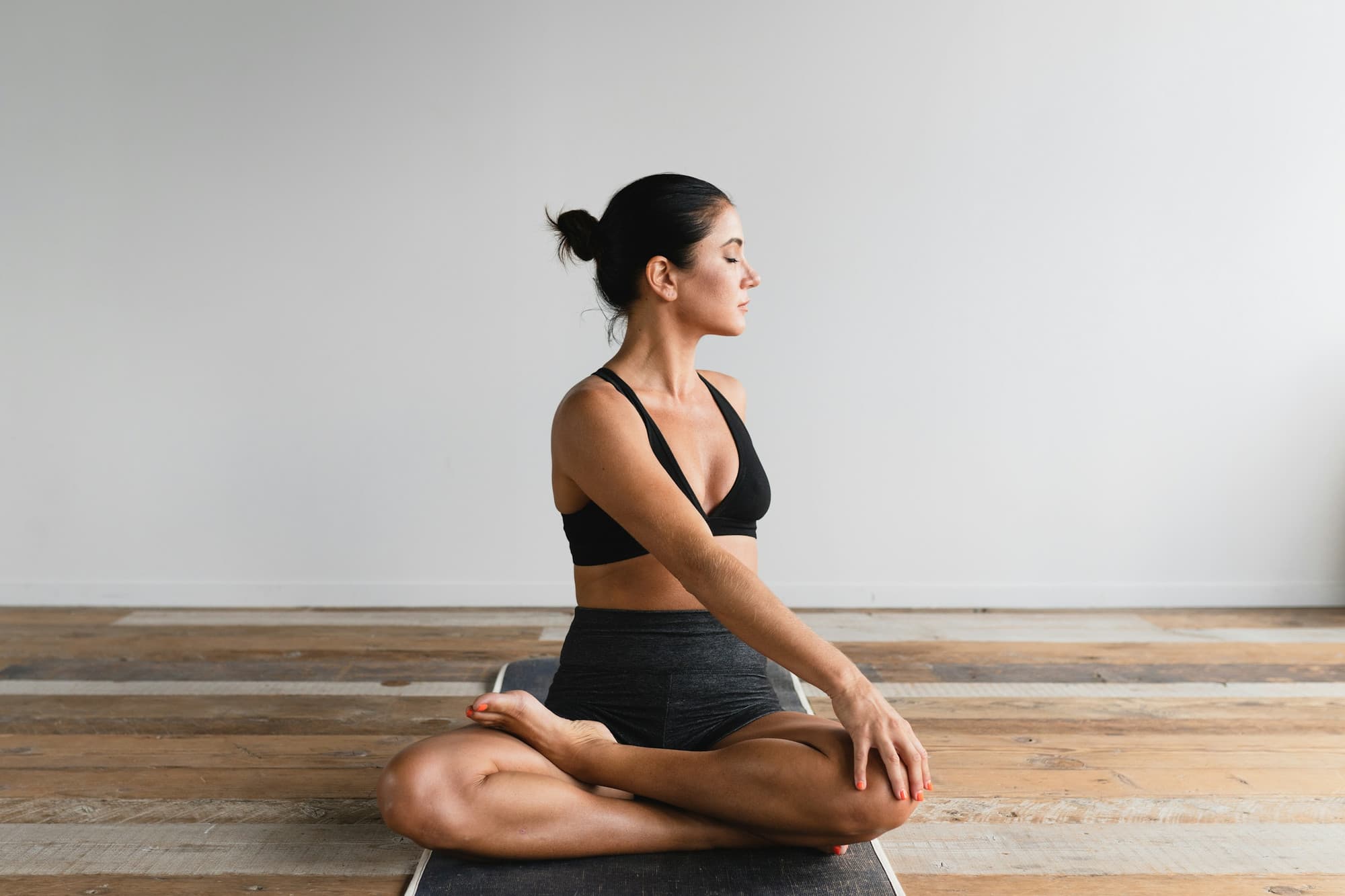 Pratiquante de Yin Yoga assise en posture calme sur son tapis